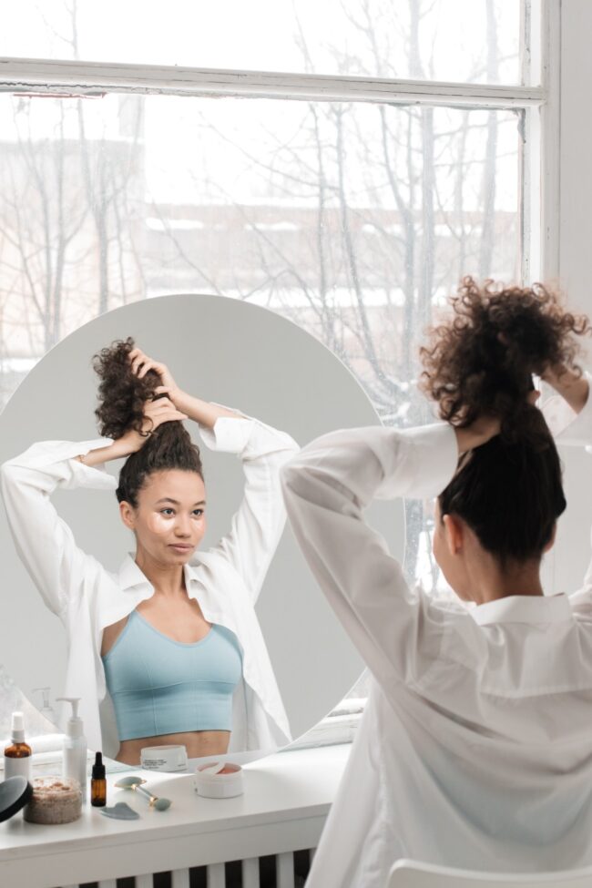 ragazza con capelli ricci fa un acconciatura ai capelli