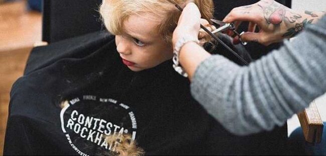 bambino biondo si taglia i capelli dal parrucchiere