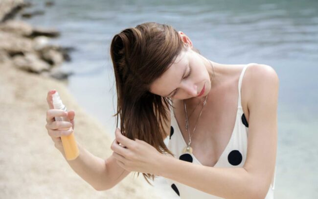 ragazza al mare spruzza prodotto per capelli