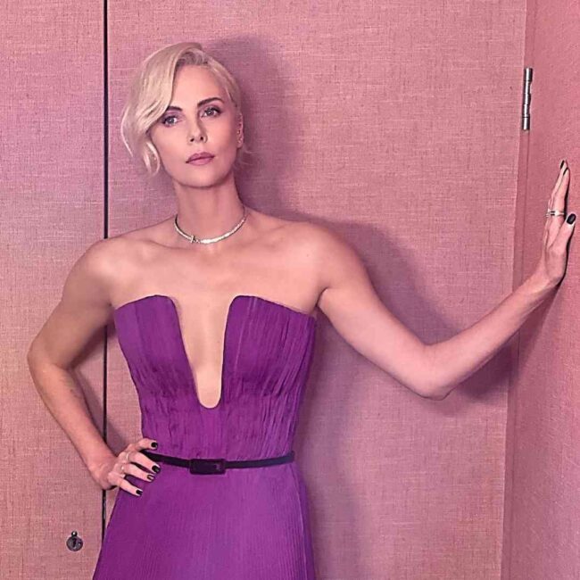 charlize teron con abito viola scollato