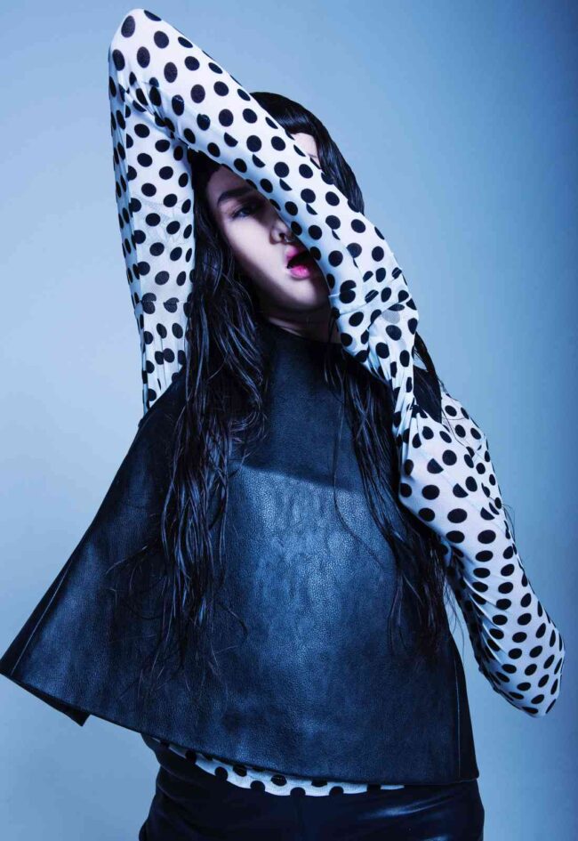 ragazza mora con maglia a pois, capelli lunghi e viso allungato