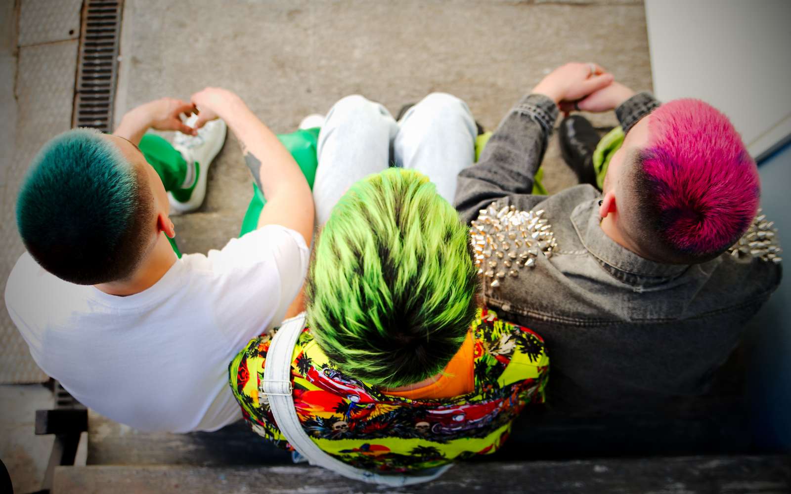 3 ragazzi visti dall'alto con capelli colorati e stile rock