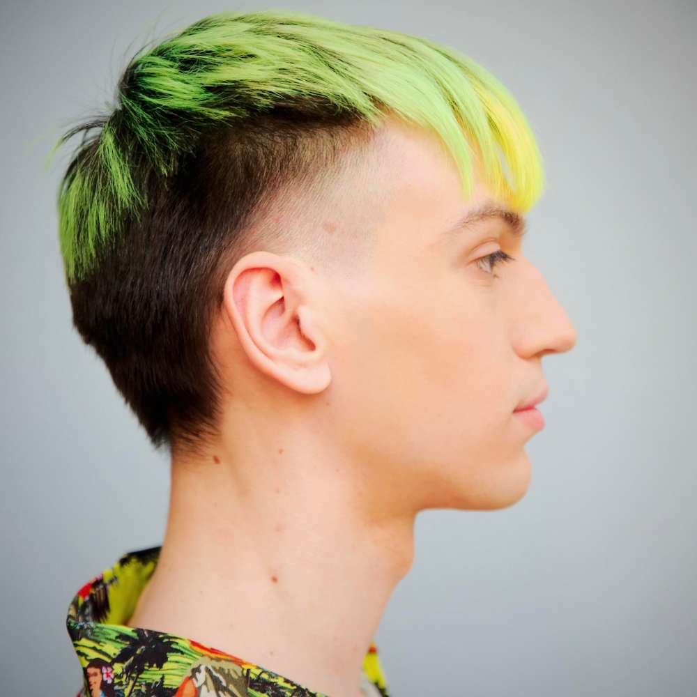 ragazzo di profilo con taglio di capelli mullet verde