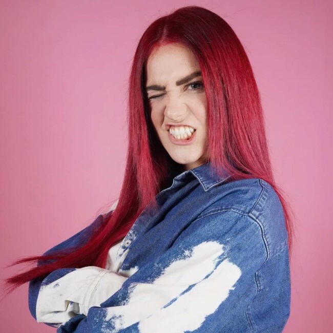 ragazza di profilo con capelli rossi lunghi lisci e giacca di jeans