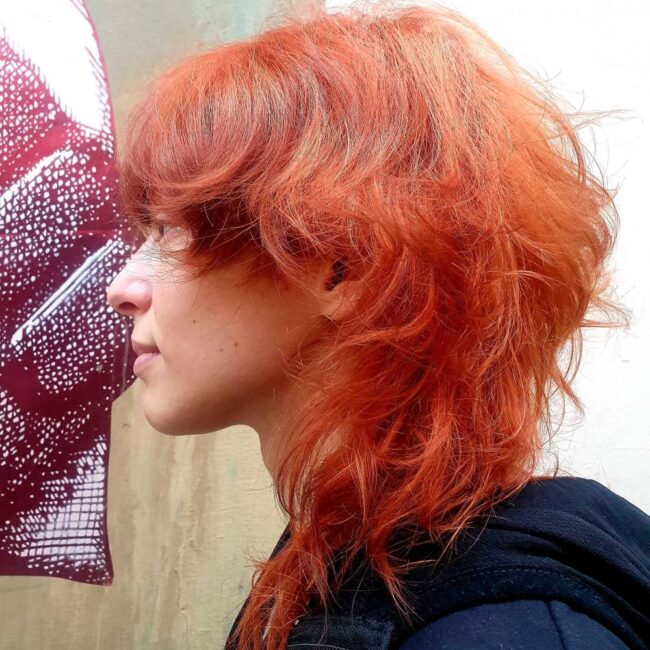 ragazza di profilo con capelli rossi e taglio wolf cut
