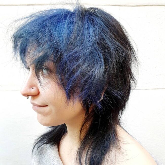 ragazza di profilo con capelli blu e taglio wolf cut